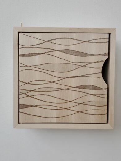 Litet skåp i massiv björk med lasergraverat mönster på dörren.